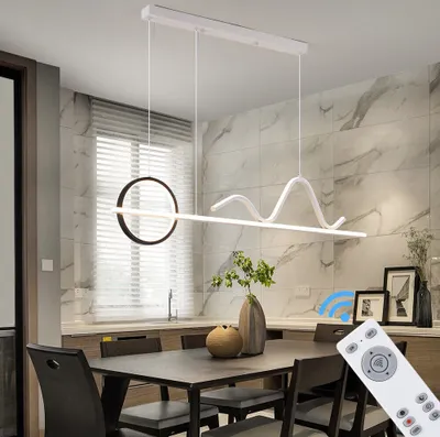 A modern dining room with a table and chairs, featuring a contemporary pendant light.