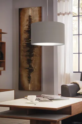 A living room scene with a pendant lamp, artwork, and a coffee table.
