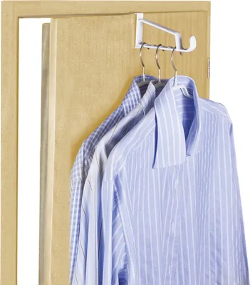 Three blue and white striped shirts are hanging on a white over-the-door hanger attached to a light brown door.