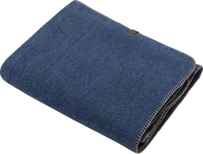 A folded blue blanket with a small brown tag on the corner.