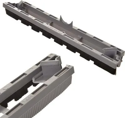 A close-up, studio shot of a gray plastic cleaning tool with black bristles, shown from multiple angles against a white background.