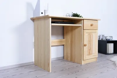 A wooden desk with a keyboard tray and a cabinet.