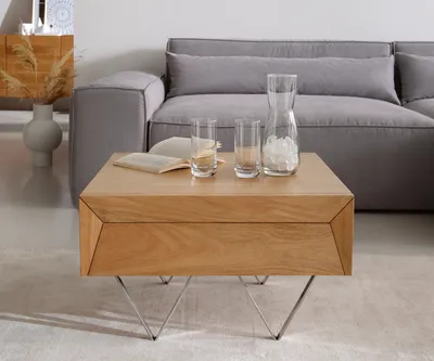 A wooden coffee table in a living room setting with a grey sofa in the background.