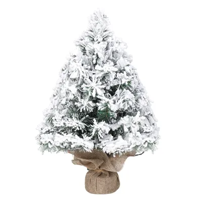 A mini artificial Christmas tree covered in artificial snow, standing in a burlap base.