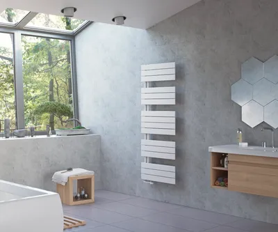 A modern bathroom with a large window overlooking trees, a bathtub, a sink, and a white towel radiator.