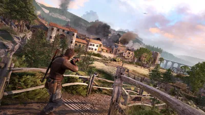 A soldier aims a rifle in a war-torn village with smoke rising from buildings and a plane flying overhead.