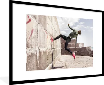 Produktbild von MuchoWow® Gerahmtes Poster Ein junger Mann, der Parkour macht 90x60 cm - Poster mit Schwarzem Bilderrahmen Wandposter Rahmen Foto Bilder - Wanddekoration - Fotos