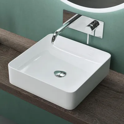 A modern bathroom sink with a wall-mounted faucet.