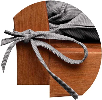 A close-up view of a gray cushion tie on a wooden surface.