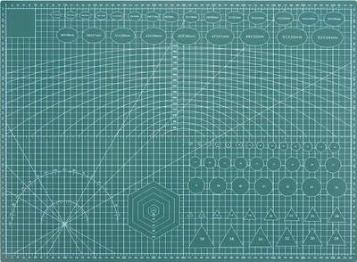 A top-down view of a self-healing cutting mat with grid lines and measurement guides.