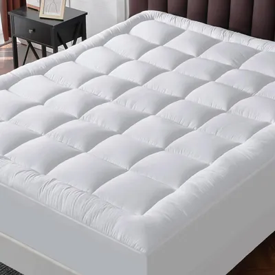 A white mattress topper on a bed.