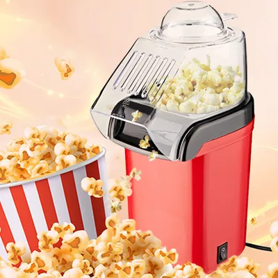 A red popcorn machine with popcorn spilling out, next to a striped popcorn bucket.