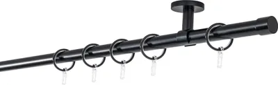A black curtain rod with rings, mounted to a ceiling.
