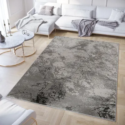 A modern living room with a sectional sofa, coffee tables, and a rug.