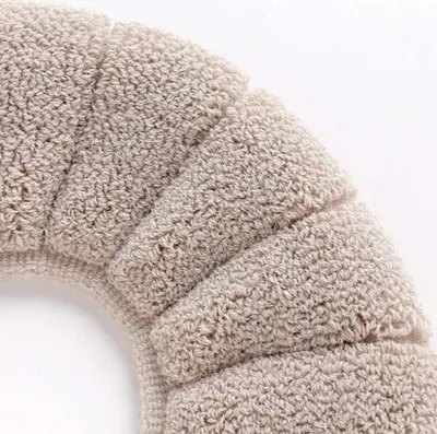A close-up view of a textured, beige toilet seat cover.
