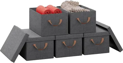 A set of five grey fabric storage boxes with brown handles, some filled with rolled towels and other items, arranged on a white background.