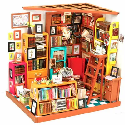 A miniature dollhouse library scene with bookshelves, books, and furniture.