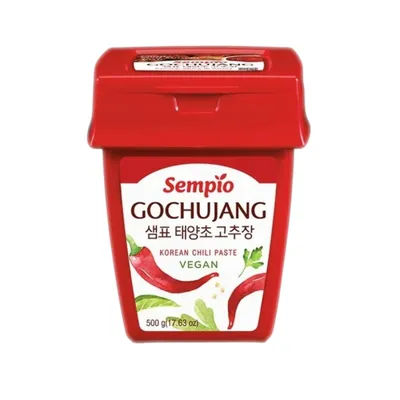A red tub of Gochujang Korean chili paste against a white background.