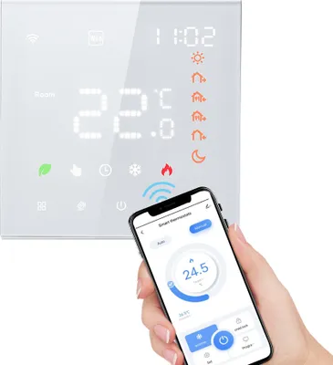 A smart thermostat is shown on a white background, with a hand holding a smartphone displaying the thermostat's app.
