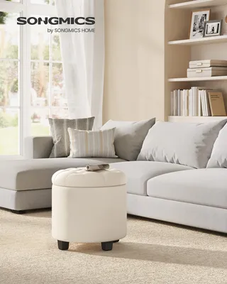 A living room scene with a sectional sofa, decorative pillows, and a round ottoman.