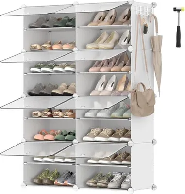 A white modular shoe rack filled with shoes, with a handbag and umbrella hanging on the side.