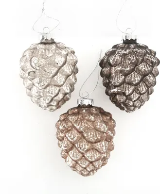 Three glass pine cone Christmas ornaments hanging against a white background.
