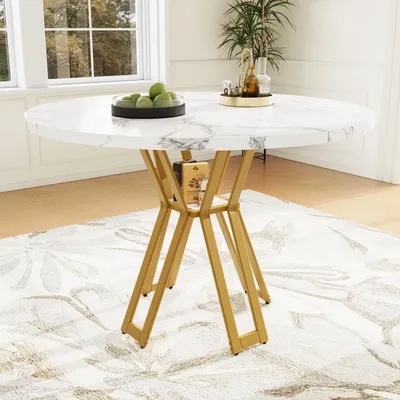 A round marble-top dining table with gold legs is shown in a well-lit room with a patterned rug.