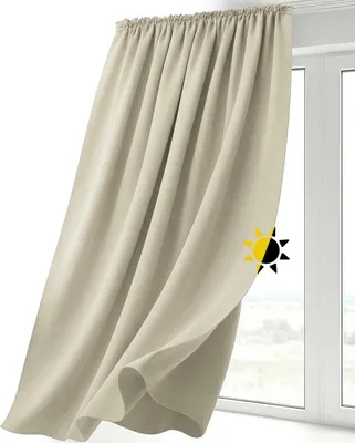 A beige curtain hanging in front of a window.