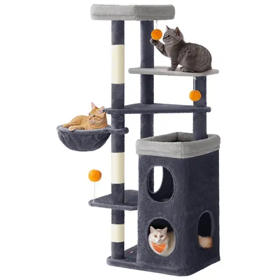 A multi-level cat tree with several platforms, a hammock, and two enclosed cubbies, featuring three cats interacting with the structure.