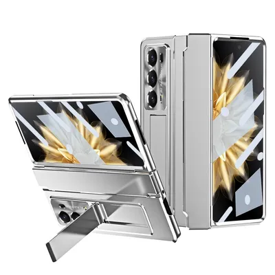 A silver foldable phone case with a built-in stand is displayed against a white background. The phone case is shown in two configurations: one folded and one unfolded with the stand extended.