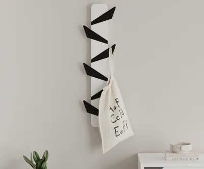 A white and black coat rack mounted on a light gray wall.