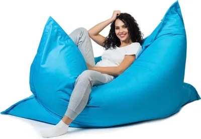A woman is sitting on a large blue beanbag chair.