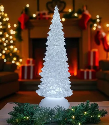 A decorative acrylic Christmas tree with LED lights sits on a table in front of a fireplace decorated for the holidays.