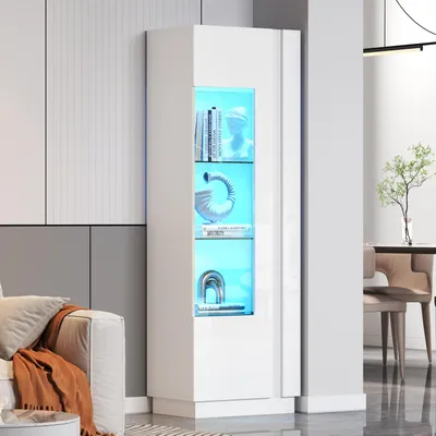 A white LED display cabinet with blue interior lighting, showcasing decorative items and books, placed in a modern living room setting next to a sofa.