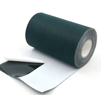 A roll of dark green tape with a white backing is partially unrolled, showing the adhesive side.