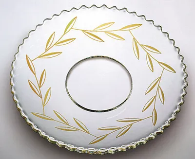 Produktbild von Glas-Kerzenmanschette - Tropfenfänger für Kerzen bis Ø 25 mm. Der Außendurchmesser der Kerzenmanschette beträgt Ø 70 mm. Hergestellt in Handarbeit aus klarem Glas. Das Ornament wird aus 21-karätigem Gold gefertigt. Schützt vor herablaufendem Wachs auf Ihrem gedeckten Tisch.