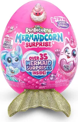 A pink egg-shaped toy package with a gold mermaid tail accessory attached to the bottom.