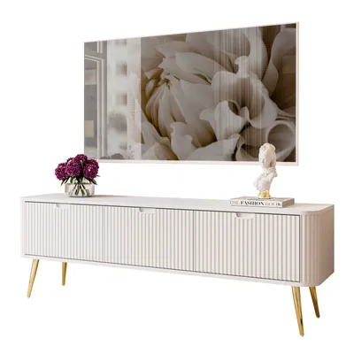 A white TV stand with gold legs, decorated with a vase of flowers and a bust on a book.