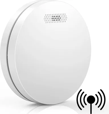 A white, circular smoke detector with a mesh grille on top, shown at an angle against a white background. A black icon representing wireless connectivity is in the lower right corner.