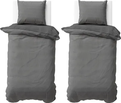 Two identical sets of bedding are laid out on white surfaces, viewed from above.
