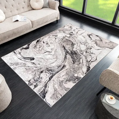 A modern living room with a sofa, rug, and armchair.