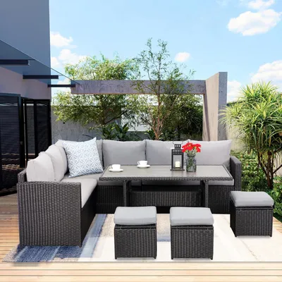 An outdoor patio set with a sectional sofa, dining table, and ottomans.