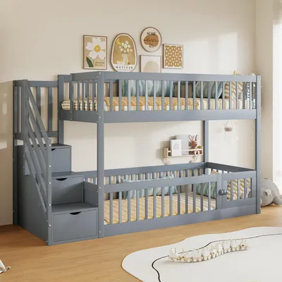 A gray wooden bunk bed with stairs and drawers, set up in a child's bedroom with wall art and decorations.