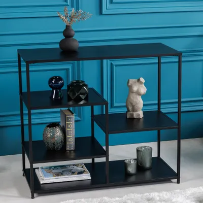 A black metal console table with decorative items on its shelves, set against a blue paneled wall.