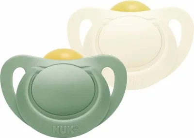 Two NUK pacifiers, one green and one cream colored, are shown against a white background.