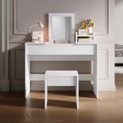 A white vanity table with a mirror and a stool in a room with decorative wall molding.