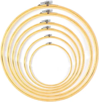 A set of wooden embroidery hoops of varying sizes, nested together.