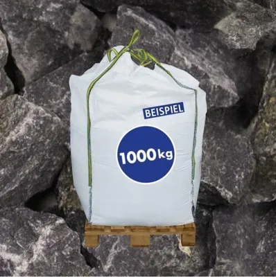A white BigBag filled with stones, placed on a wooden pallet, with a background of large stones.