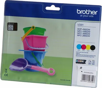The image shows the packaging of Brother LC221 ink cartridges, with a stack of colorful toy buckets and a shovel in the foreground.