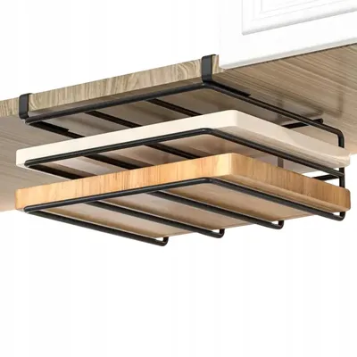 A black metal rack holding three cutting boards, attached to the underside of a wooden surface.